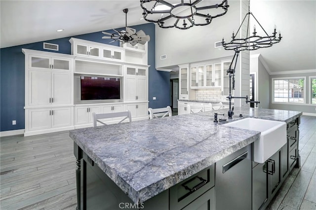 777 Oak Knoll St, Brea, CA 92821 - kitchen featuring a chandelier, vaulted ceiling, a kitchen island with sink, light wood-style flooring, and white cabinets