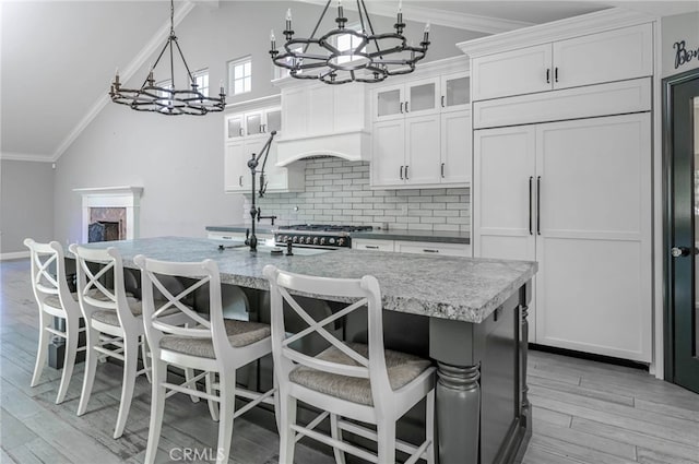 777 Oak Knoll St, Brea, CA 92821 - kitchen featuring lofted ceiling, a chandelier, light wood-style flooring, decorative backsplash, and an island with sink