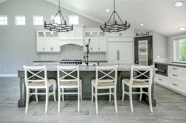 777 Oak Knoll St, Brea, CA 92821 - kitchen with a chandelier, lofted ceiling, decorative backsplash, a kitchen island with sink, and built in appliances