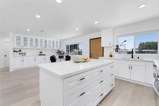 1541 2nd St, Duarte, CA 91010 - kitchen with light countertops, glass insert cabinets, a center island, recessed lighting, and light wood-style floors