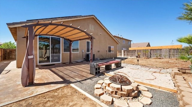 13849 Jackson St, Oak Hills, CA 92344 - rear view of property featuring an outdoor fire pit, a fenced backyard, stucco siding, a patio area, and a pergola