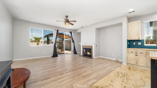 13849 Jackson St, Oak Hills, CA 92344 - living room with light wood-type flooring, a tile fireplace, and ceiling fan