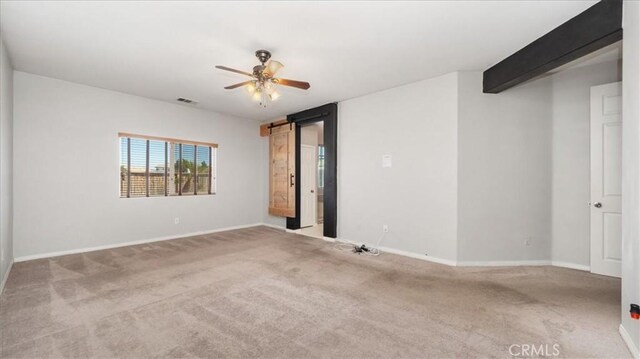 13849 Jackson St, Oak Hills, CA 92344 - carpeted spare room with ceiling fan and a barn door