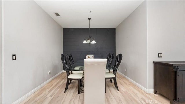13849 Jackson St, Oak Hills, CA 92344 - dining space with light wood-type flooring, a chandelier, and an accent wall