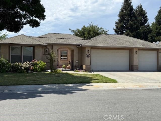 384 Papst Ave, Orland, CA 95963 - view of front of home with an attached garage, driveway, stucco siding, and a front lawn