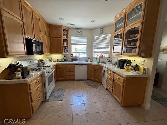 384 Papst Ave, Orland, CA 95963 - kitchen with white appliances, tile countertops, light tile patterned flooring, open shelves, and recessed lighting