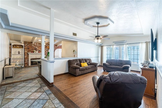 625 Balboa Dr, Corona, CA 92879 - living area with a textured ceiling, ceiling fan, a fireplace, and a wall mounted air conditioner