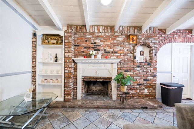 625 Balboa Dr, Corona, CA 92879 - unfurnished living room featuring stone tile flooring, beam ceiling, and a fireplace with raised hearth
