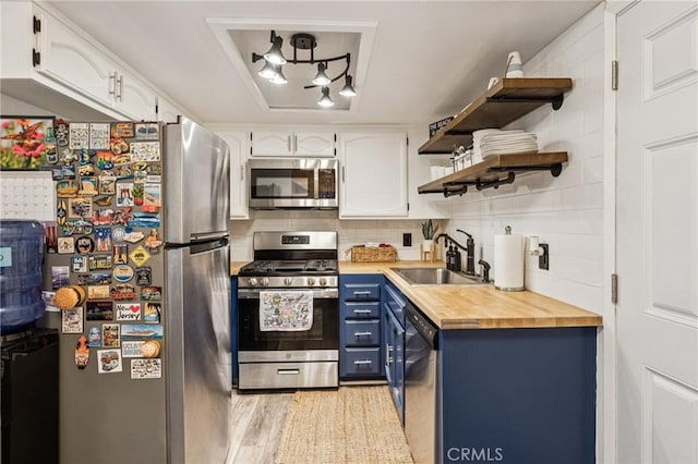 2444 La Costa Ct, Oceano, CA 93445 - kitchen with appliances with stainless steel finishes, blue cabinetry, open shelves, and white cabinets