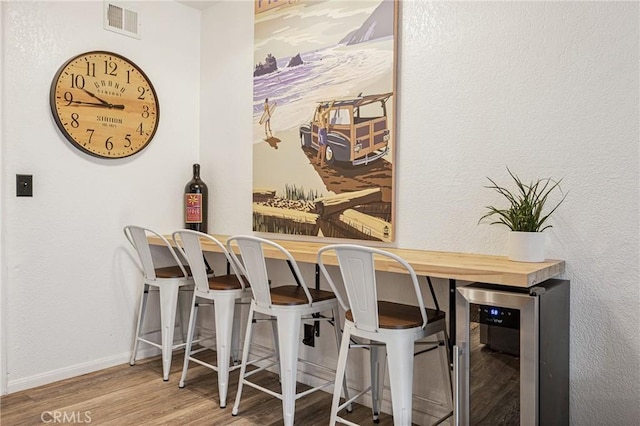 2444 La Costa Ct, Oceano, CA 93445 - dining area with wine cooler, wood finished floors, and a bar