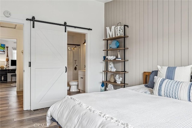 2444 La Costa Ct, Oceano, CA 93445 - bedroom featuring a barn door, wood finished floors, and connected bathroom