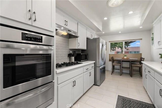 2816 E Alden Pl, Anaheim, CA 92806 - kitchen featuring stainless steel appliances, a warming drawer, under cabinet range hood, backsplash, and light countertops