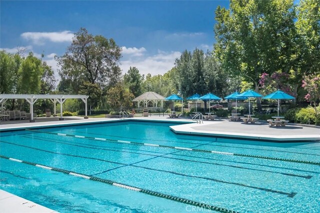 26309 Emerald Dove Dr, Valencia, CA 91355 - community pool with a patio area, a pergola, and view of scattered trees