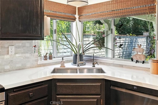 26309 Emerald Dove Dr, Valencia, CA 91355 - kitchen view of stainless steel dishwasher, dark brown cabinetry, light countertops, and decorative backsplash