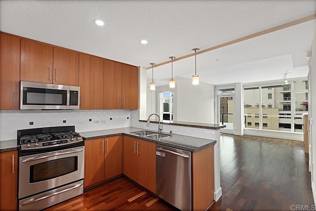 325 7th Ave Unit 609, San Diego, CA 92101 - kitchen featuring stainless steel appliances, a peninsula, dark wood-type flooring, brown cabinets, and recessed lighting