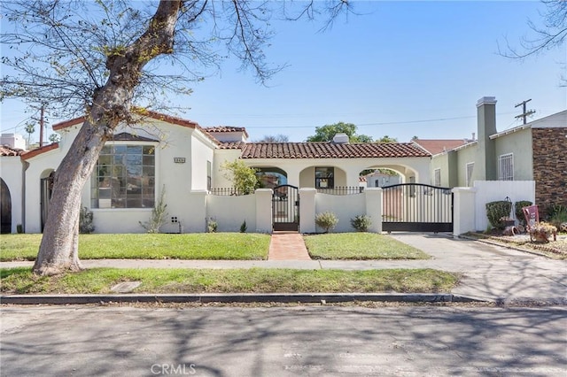 3924 Dublin Ave, Los Angeles, CA 90008 - mediterranean / spanish-style home featuring a gate, stucco siding, a fenced front yard, a tiled roof, and driveway