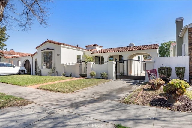 3924 Dublin Ave, Los Angeles, CA 90008 - mediterranean / spanish-style house with a gate, stucco siding, a tile roof, and driveway