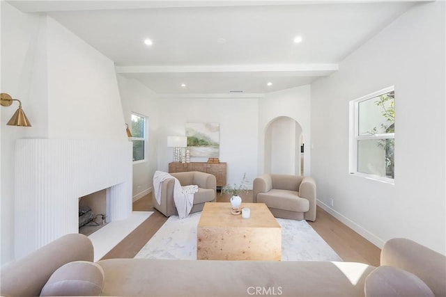3924 Dublin Ave, Los Angeles, CA 90008 - living area featuring arched walkways, wood finished floors, a fireplace with raised hearth, recessed lighting, and beamed ceiling