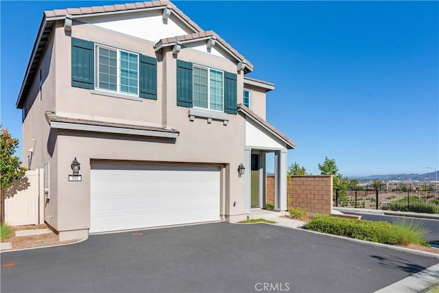 501 Pablo Rd Unit 48, Lake Elsinore, CA 92530 - view of front facade with a garage, stucco siding, asphalt driveway, and a tiled roof