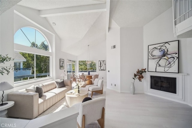 26970 Flo Ln Unit 310, Canyon Country, CA 91351 - living room featuring wood finished floors, a glass covered fireplace, beamed ceiling, high vaulted ceiling, and a textured ceiling