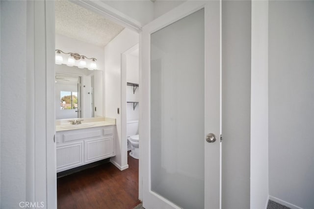 26970 Flo Ln Unit 310, Canyon Country, CA 91351 - half bathroom featuring vanity, wood finished floors, and a textured ceiling