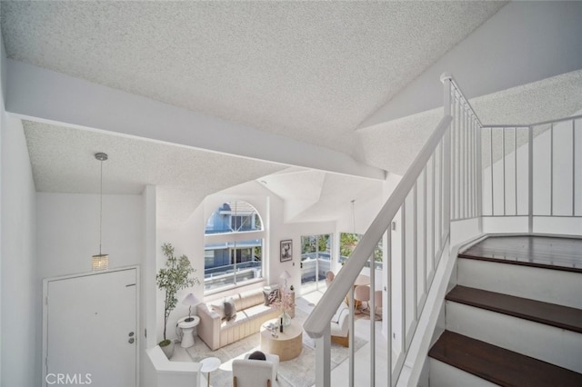 26970 Flo Ln Unit 310, Canyon Country, CA 91351 - stairway featuring a textured ceiling and vaulted ceiling
