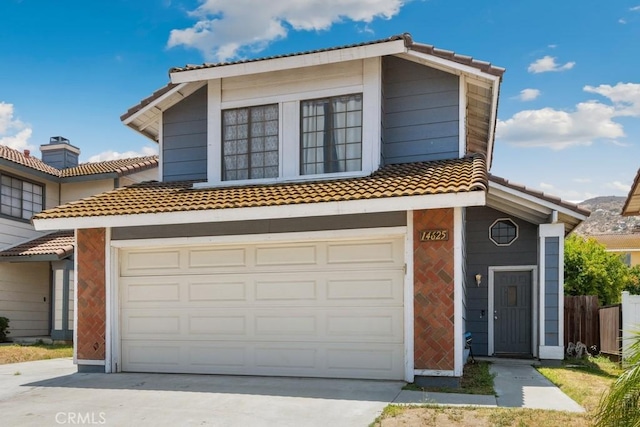 14625 Mountain High Dr, Fontana, CA 92337 - view of property featuring a tile roof, concrete driveway, and a garage