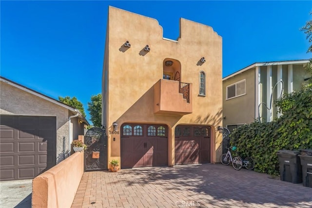 3606 W Chandler Blvd, Burbank, CA 91505 - view of front of house with a balcony, a garage, stucco siding, and decorative driveway