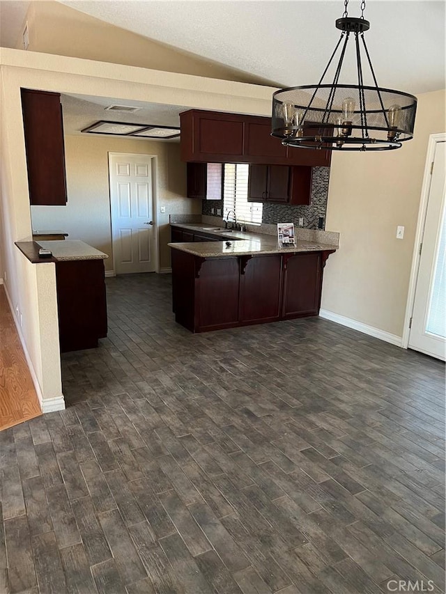 10178 Olivine Rd, Victorville, CA 92392 - kitchen with a peninsula, a chandelier, dark wood-style flooring, a kitchen breakfast bar, and vaulted ceiling