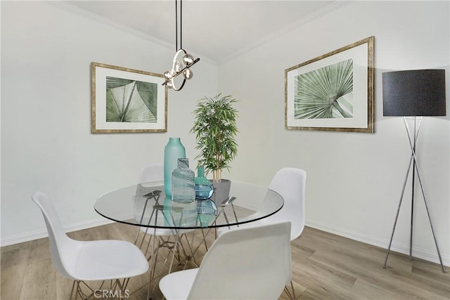 10861 Moorpark St Unit 203, North Hollywood, CA 91602 - dining area featuring ornamental molding, wood finished floors, and a chandelier