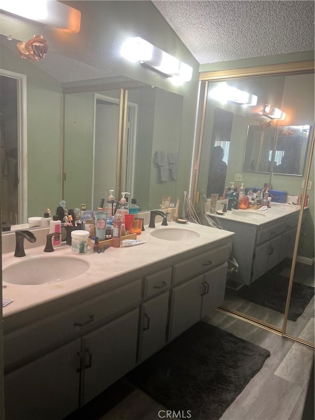 1522 Lahaina St, West Covina, CA 91792 - full bath with a textured ceiling, double vanity, wood finished floors, and vaulted ceiling