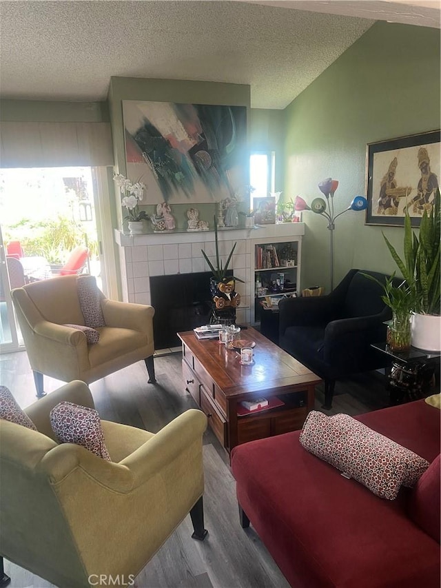 1522 Lahaina St, West Covina, CA 91792 - living area featuring wood finished floors, a textured ceiling, and a fireplace