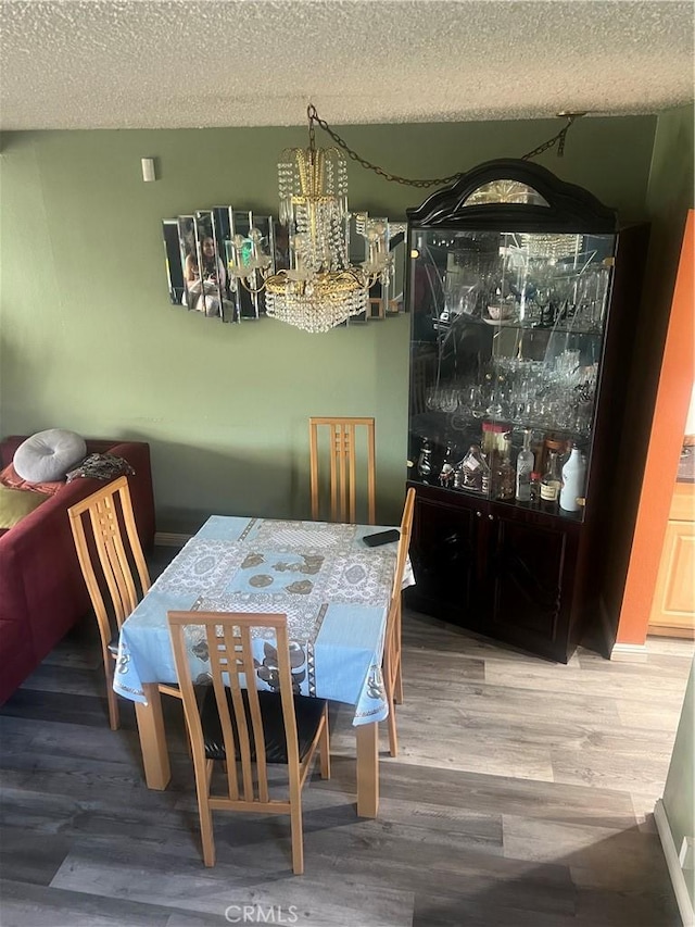 1522 Lahaina St, West Covina, CA 91792 - dining room featuring a textured ceiling, wood finished floors, and a chandelier