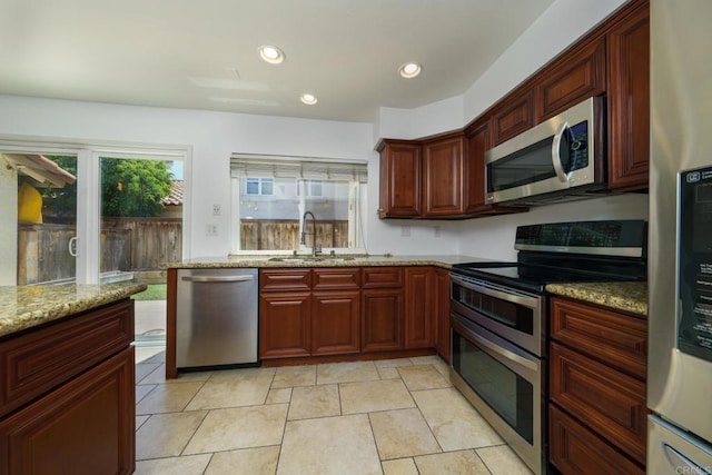 1651 S Juniper St Unit 172, Escondido, CA 92025 - kitchen with stainless steel appliances, light stone counters, reddish brown cabinets, and recessed lighting