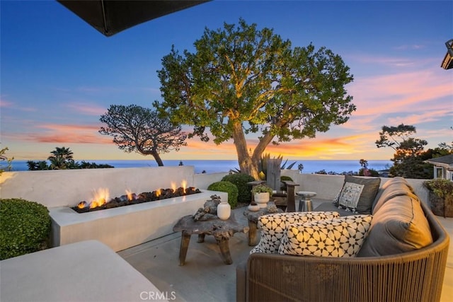 21611 Ocean Vista Dr, Laguna Beach, CA 92651 - patio terrace at dusk with a fire pit, a patio area, and a water view