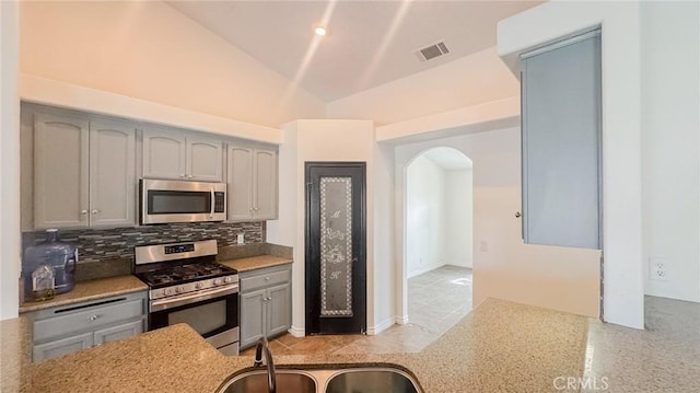 11126 Arena Rd, Pinon Hills, CA 92372 - kitchen featuring appliances with stainless steel finishes, gray cabinets, tasteful backsplash, arched walkways, and lofted ceiling