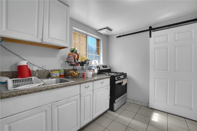 6059 Riverside Ave, Huntington Park, CA 90255 - kitchen featuring stainless steel gas stove, a barn door, white cabinetry, light tile patterned floors, and dark countertops
