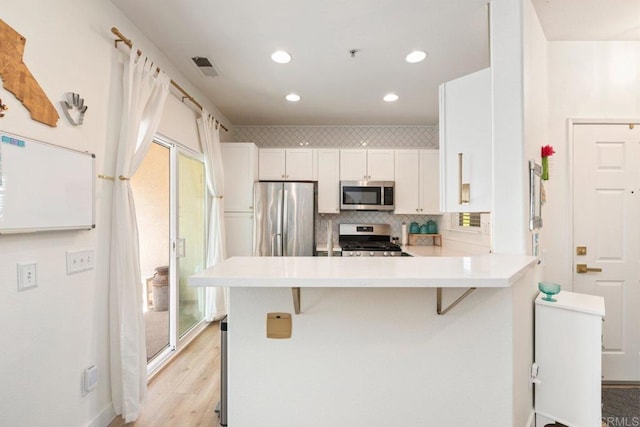 26396 Arboretum Way Unit 2908, Murrieta, CA 92563 - kitchen featuring stainless steel appliances, light countertops, decorative backsplash, a peninsula, and white cabinets