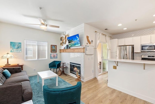 26396 Arboretum Way Unit 2908, Murrieta, CA 92563 - living area with ceiling fan, light wood-style floors, a tiled fireplace, and recessed lighting