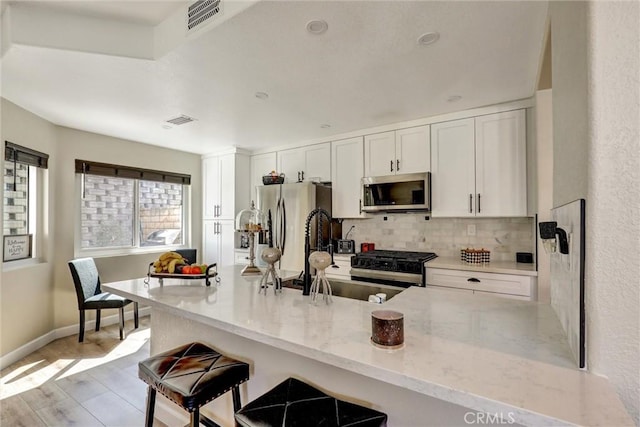 2000 San Antonio Dr, Corona, Corona, CA 92882 - kitchen featuring stainless steel appliances, backsplash, light wood-style flooring, and white cabinetry