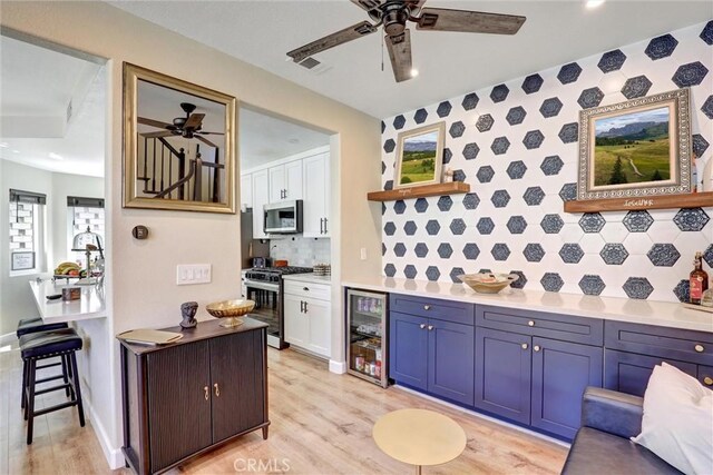 2000 San Antonio Dr, Corona, Corona, CA 92882 - kitchen with beverage cooler, stainless steel appliances, a ceiling fan, open shelves, and light wood-style floors