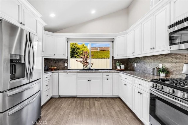 33554 Halyard Dr, Dana Point, CA 92629 - kitchen featuring appliances with stainless steel finishes, vaulted ceiling, white cabinets, stone countertops, and light wood-style floors
