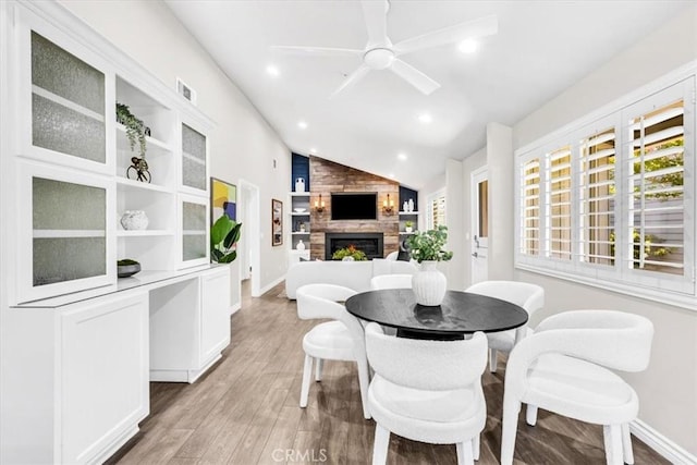 33554 Halyard Dr, Dana Point, CA 92629 - dining area with light wood-style flooring, a large fireplace, vaulted ceiling, a ceiling fan, and recessed lighting