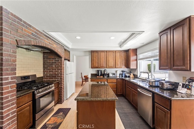 1825 Calle Madrid, Rowland Heights, CA 91748 - kitchen with appliances with stainless steel finishes, a kitchen island, a raised ceiling, dark stone countertops, and light wood-style floors