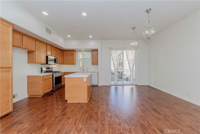 2245 Chaffee St, Fullerton, CA 92833 - kitchen with appliances with stainless steel finishes, a chandelier, dark wood finished floors, light countertops, and a center island