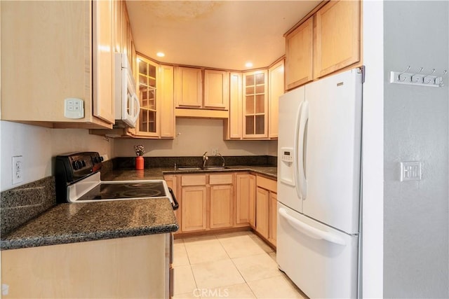 1620 Neil Armstrong St Unit 306, Montebello, CA 90640 - kitchen with white appliances, light brown cabinetry, dark countertops, light tile patterned floors, and glass insert cabinets