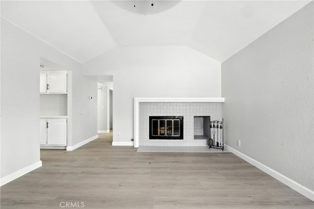 10655 Springfield Dr, Rancho Cucamonga, CA 91730 - unfurnished living room with vaulted ceiling, light wood-type flooring, and a glass covered fireplace