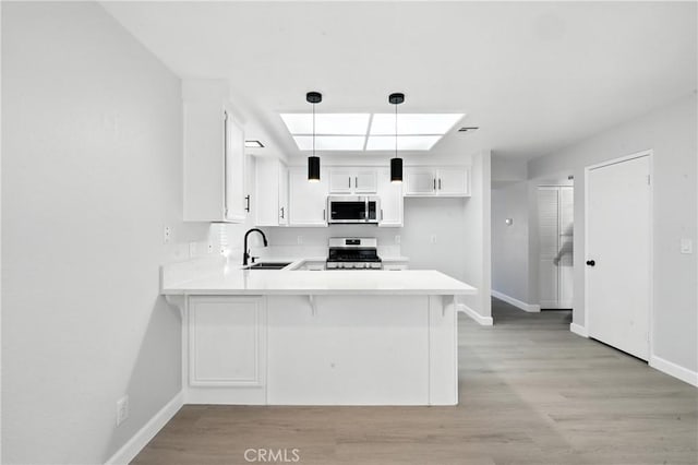 10655 Springfield Dr, Rancho Cucamonga, CA 91730 - kitchen with stainless steel appliances, a peninsula, light countertops, white cabinets, and pendant lighting