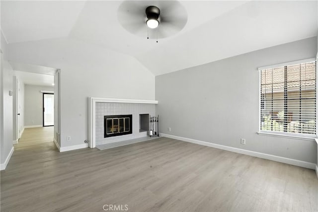 10655 Springfield Dr, Rancho Cucamonga, CA 91730 - unfurnished living room featuring vaulted ceiling, light wood-style floors, healthy amount of natural light, and a brick fireplace