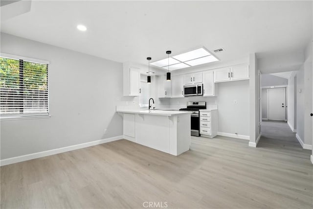 10655 Springfield Dr, Rancho Cucamonga, CA 91730 - kitchen featuring stainless steel appliances, a peninsula, light wood-type flooring, light countertops, and decorative light fixtures